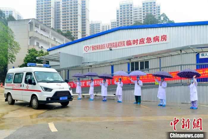 图为广西版“小汤山”医务人员送治愈患者离开。 李安祺 摄 广西版“小汤山”医院在院治疗近半数确诊患者治愈出院